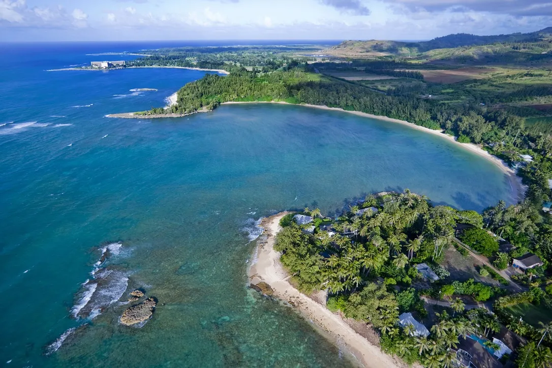 Aerial view of Kawela Bay crescent beach and vacation homes near Turtle Bay